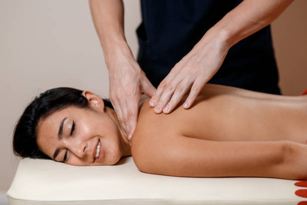 istock A young woman gets a massage procedure. Masseur makes back massage 1201249986