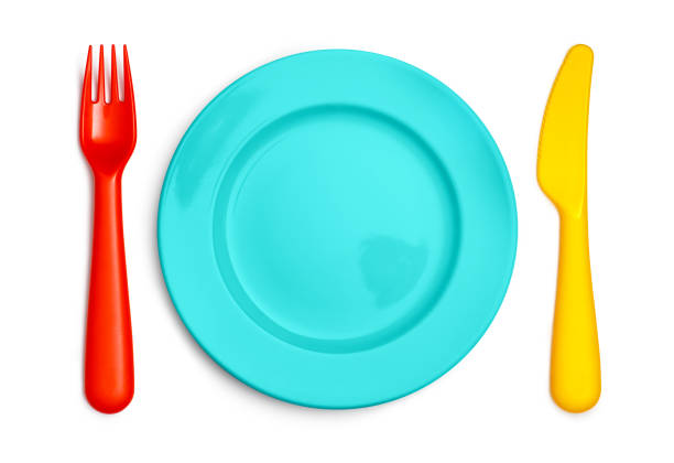 Colorful kids fork, plate and knife on white
