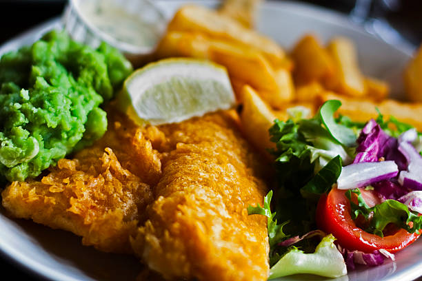 Fish and Chips Photo of Britain's most Favorited food, Fish and Chips with side salad, mushy pees and tartar sauce. fritter photos stock pictures, royalty-free photos & images
