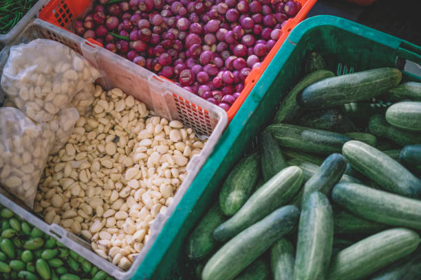 vegetable stall with beans, onion, cucumber display from top in the baskets