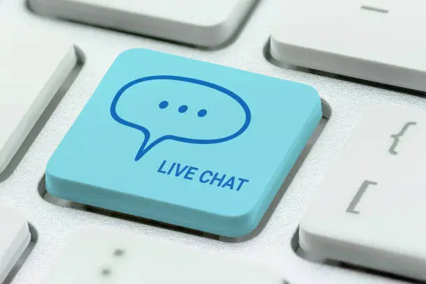 Photo of Live chat online conversation, digital web messaging, social network concept : Close-up of a computer keyboard with words LIVE CHAT and a message balloon, depict customer service via instant message