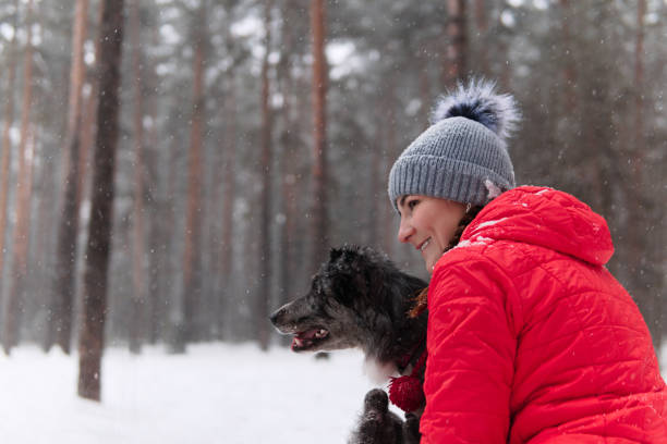 istock young woman wits her dog in a winter forest 1201257183