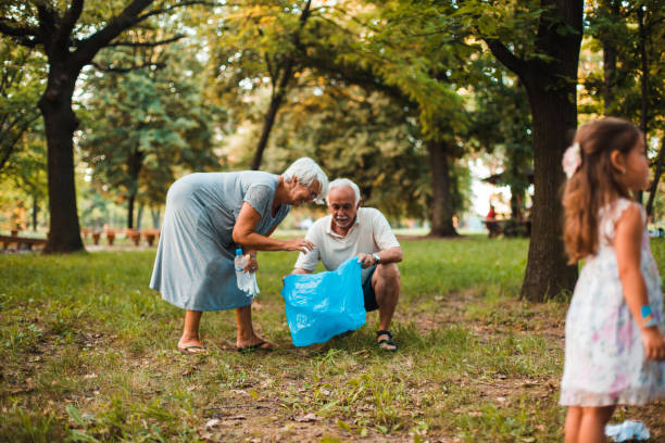 istock Senior couple recycling garbage from the park 1201260091