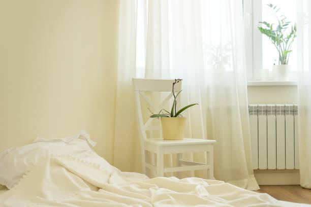 istock Light pastel bedroom interior, bed, white chair, window, light curtains. 1201263193