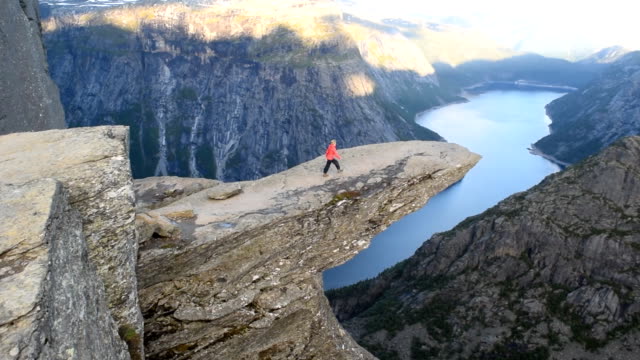 Girl on Trolltung, Norway. Slow motion video.