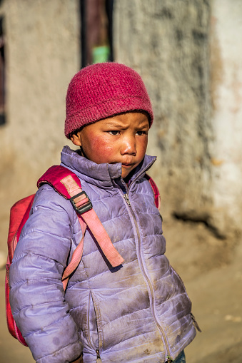 Tibetan little girl standing next to her parents house, small village in Upper Mustang. Mustang region is the former Kingdom of Lo and now part of Nepal,  in the north-central part of that country, bordering the People's Republic of China on the Tibetan plateau between the Nepalese provinces of Dolpo and Manang.