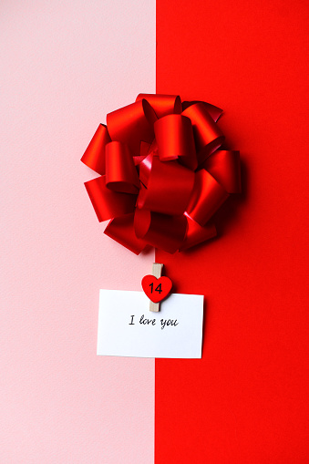 Note “I love you” with a bow on a colorful background.