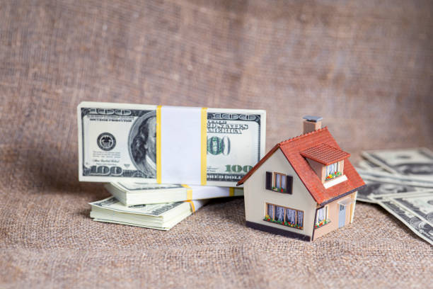 A small copy of the house is in dollars. stock photo