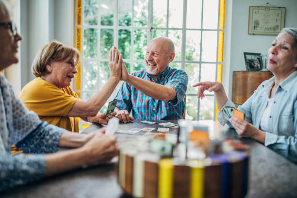 istock Group of seniors playing cards together 1201271912