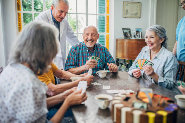 istock Group of seniors playing cards together 1201272536