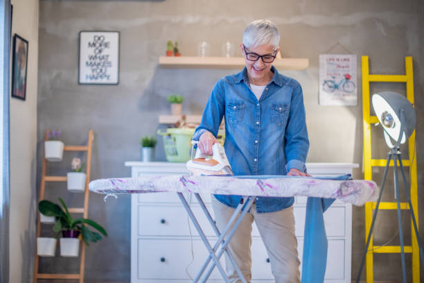 istock Happy senior woman ironing her clothes. 1201276048