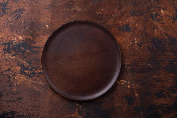 Empty plate and linen napkin on brown wooden background Copy space stock photo