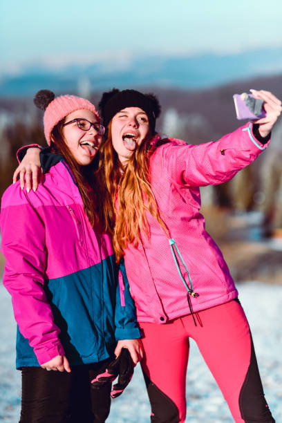 istock Two Females Taking Selfie On Snowy Mountain 1201278721
