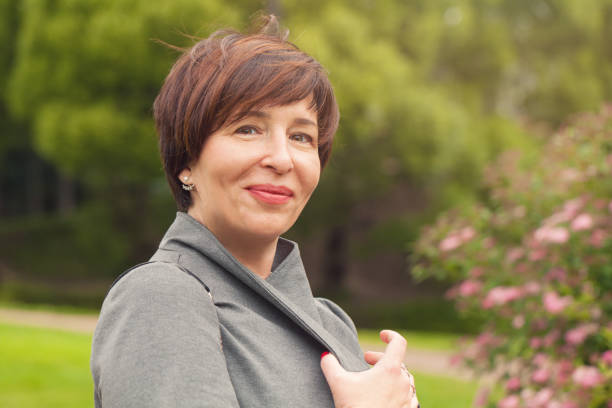 かなり成熟した女性リラックスアウトドア - short hair women smiling brown hair ストックフォトと画像