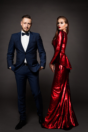 Luxury Couple, Beautiful Fashion Woman in Red Dress, Elegant Man in Suit Tuxedo, Studio Portrait