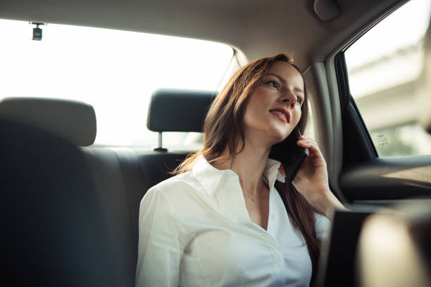 istock Businesswoman using smart phone in a car 1201280154