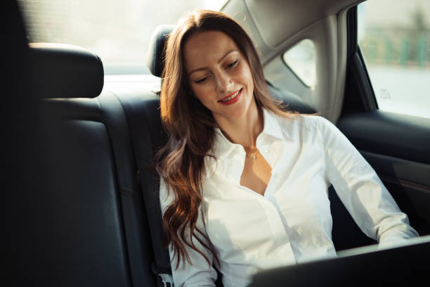 istock Businesswoman using laptop in a car 1201280254