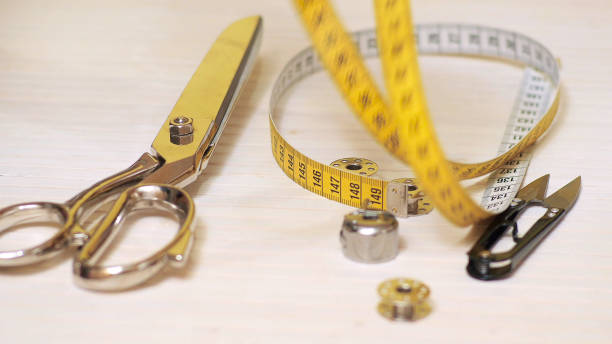 istock Tailor tools isolated on wooden background. Scissors, needle, Tailoring Meter, hand 1201280282