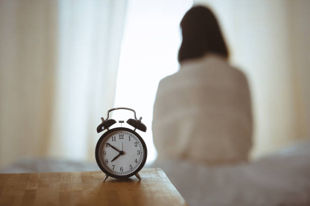 Woman stretching hands in bed after wake up, sun flare . Brunette entering a day happy and relaxed after good night sleep and back view. Concept of a new day and joyful weekend Woman stretching hands in bed after wake up, sun flare . Brunette entering a day happy and relaxed after good night sleep and back view. Concept of a new day and joyful weekend. smash alarm clock stock pictures, royalty-free photos & images