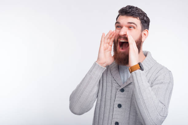Amazed young man is shouting some good news or promotion.
