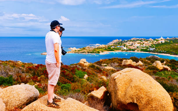 istock Man with camera at rocks in Capo Testa Mediterranean sea reflex 1201285964