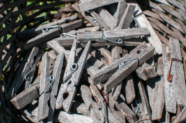 Pile of weathered wooden laundry clamps closeup in reed basket