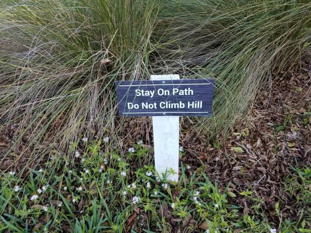 istock stay on path do not climb hill sign and plants 1201287105