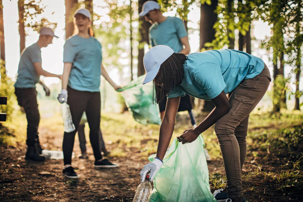 istock Volunteers with garbage bags cleaning park area 1201287173