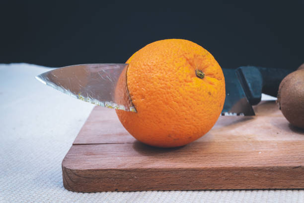 istock oranges cut with a knife and kiwi on a wooden board 1201288823
