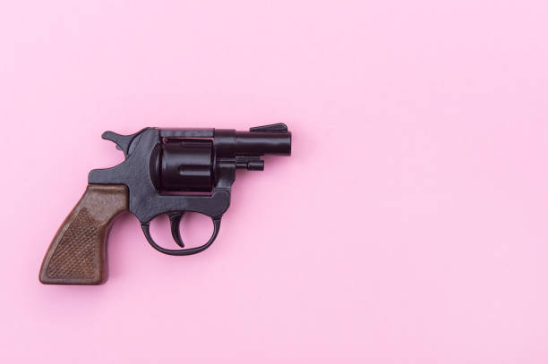 istock Black gun on a pink background. 1201289080