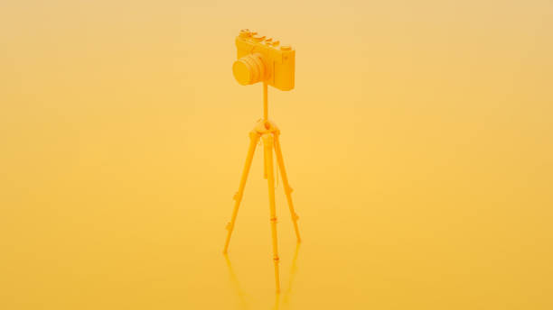 Photo studio concept. Camera and tripod on yellow background. 3d illustration.