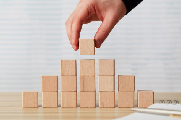 istock Hand arranging final  wooden block on pyramid 1201290129