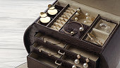 Top view of Open brown leather jewelry box. Golden jewelry in brown leather accessories organizer
