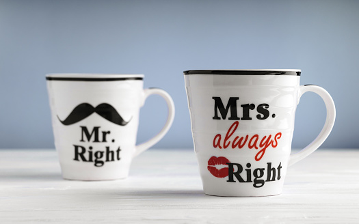 Two mugs with printed text Mr. right and Mrs. always right. Funny phrase about couples life printed on mug