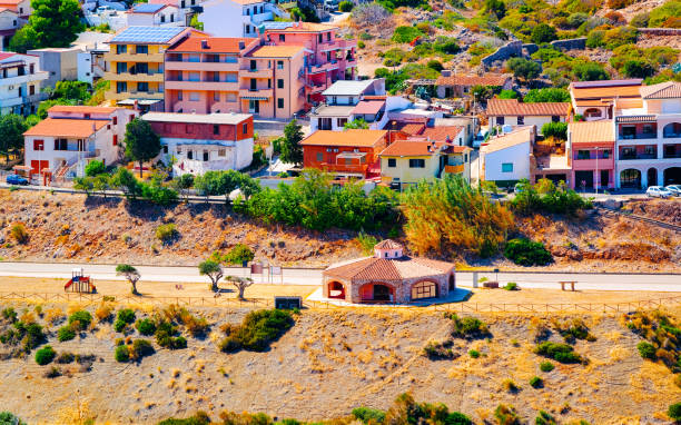 Cityscape of Buggerru city near Mediterranean Sea in South Sardinia reflex Cityscape with Buggerru city with cottage house architecture at the Mediterranean Sea in South Sardinia in Italy. Sardinian Italian small town in Sardegna. Buggerru stock pictures, royalty-free photos & images