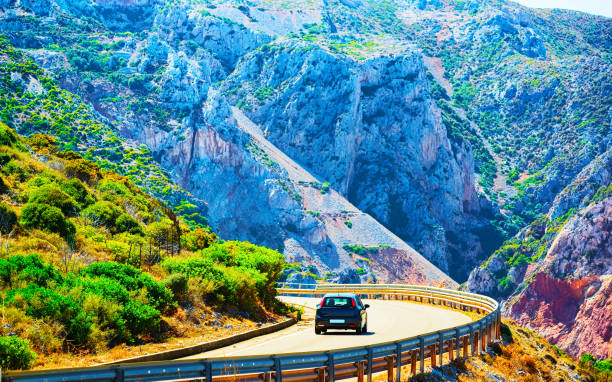 istock Car on road at Buggerru in Carbonia Iglesias Sardinia reflex 1201294050
