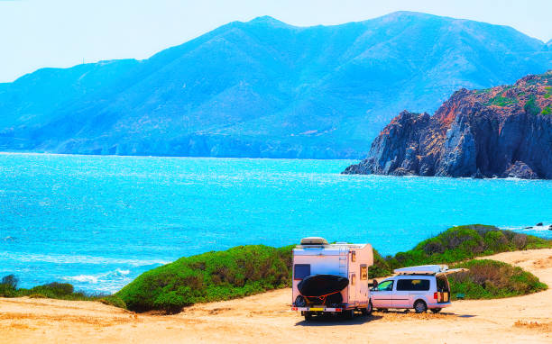 istock Car and Camper at Capo Pecora Mediterranean sea Sardinia reflex 1201294224