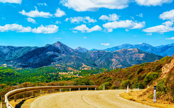 Road and the Mountains in Buggerru Sardinia reflex Empty road without cars of Buggerru in Sardinia Island in Italy summer. Transport driving on highway of Europe. Holiday on motorway. Cagliari province. Mountains on background. Mixed media. Buggerru stock pictures, royalty-free photos & images