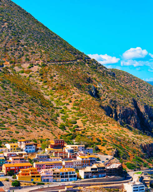 Scenery with Buggerru city with houses architecture at hills reflex Cityscape with Buggerru city with cottage house architecture at the Mediterranean Sea in South Sardinia in Italy. Sardinian Italian small town in Sardegna. Buggerru stock pictures, royalty-free photos & images