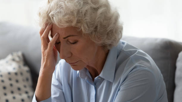 istock Close up unhappy older woman touching forehead, suffering from headache 1201295568