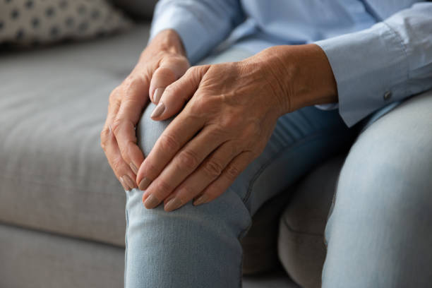 istock Close up older woman touching knee with hands, feeling pain 1201295580