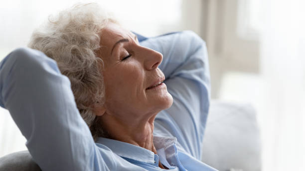 istock Close up peaceful older woman relaxing on cozy sofa 1201295586
