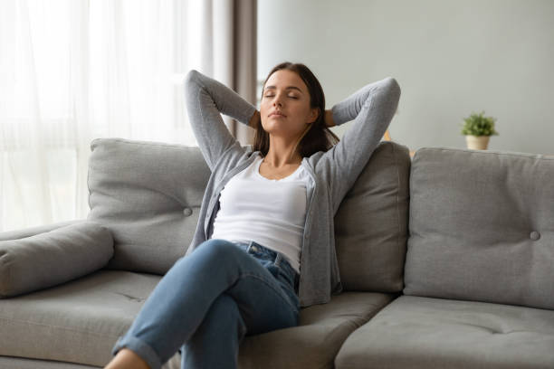istock Beautiful young woman relaxing on comfortable couch at home 1201295596