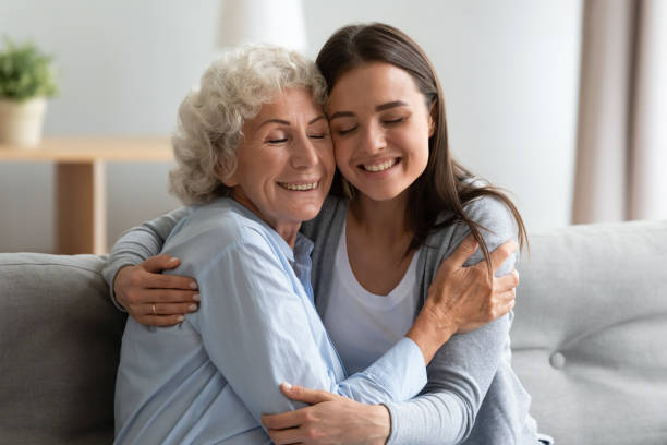 uśmiechnięta babcia i wnuczka przytulanie, ciesząc się razem - healthcare and medicine pain candid senior adult zdjęcia i obrazy z banku zdjęć