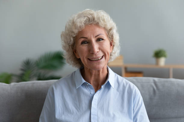 istock Head shot portrait beautiful older woman looking at camera 1201295643