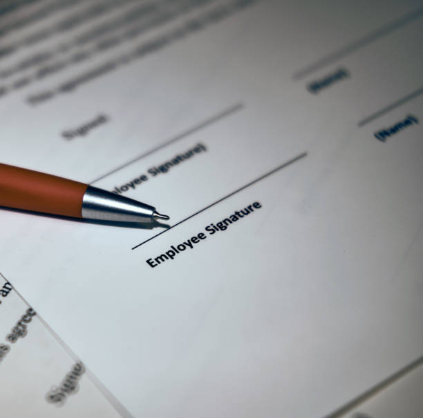 istock Contract sheet with a pen on a wooden background 1201297880