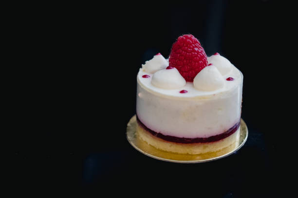 istock Luxury white cheesecake mousse cake decorated with fresh raspberries on a dark background. Flat lay. Close-up. Copy space 1201300950