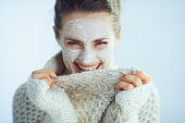happy modern woman with white facial mask playing with clothes