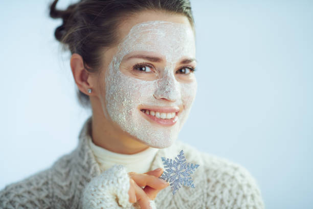 femme élégante de sourire avec le masque facial blanc affichant le flocon de neige - human skin dry human face peeling photos et images de collection