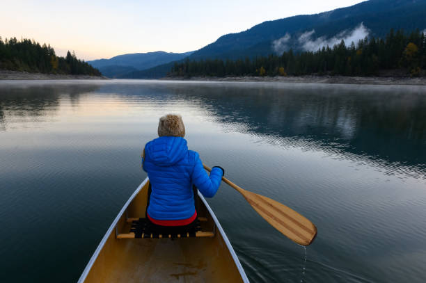 istock Woman canoeing on a mountain lake 1201302278